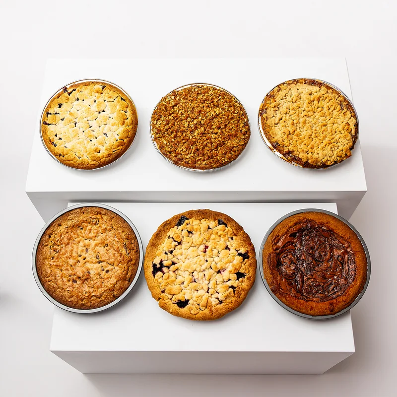 Six A Third Slice pies arranged together on white display blocks